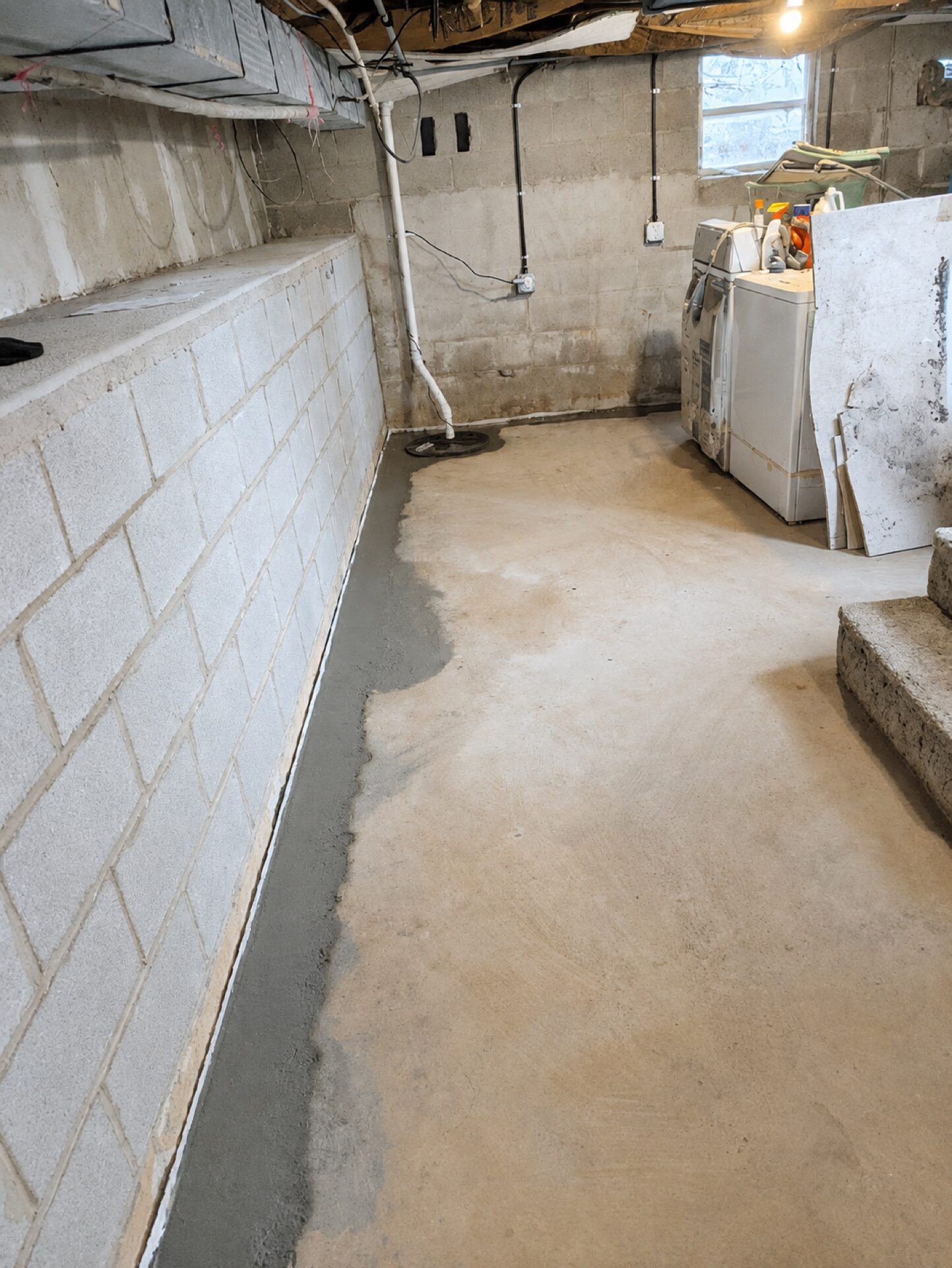 View of a newly rebuilt basement foundation wall constructed of concrete block.