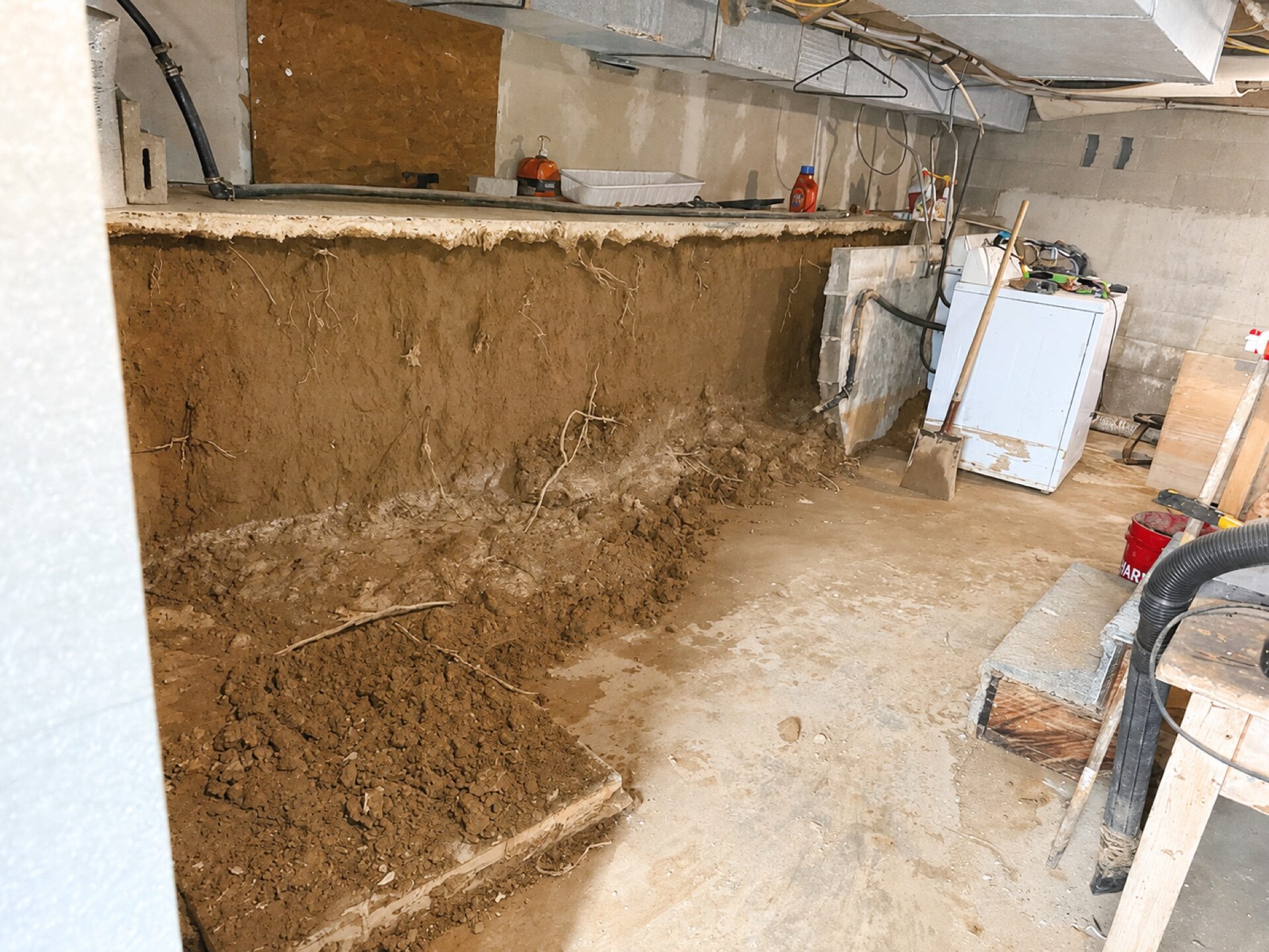 Damaged foundation masonry exposed during repair, showing deteriorated brickwork and soil intrusion.